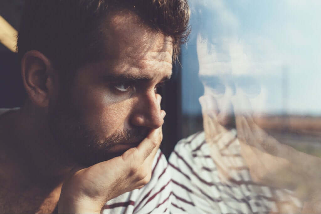 Homem pensativo em janela de trem