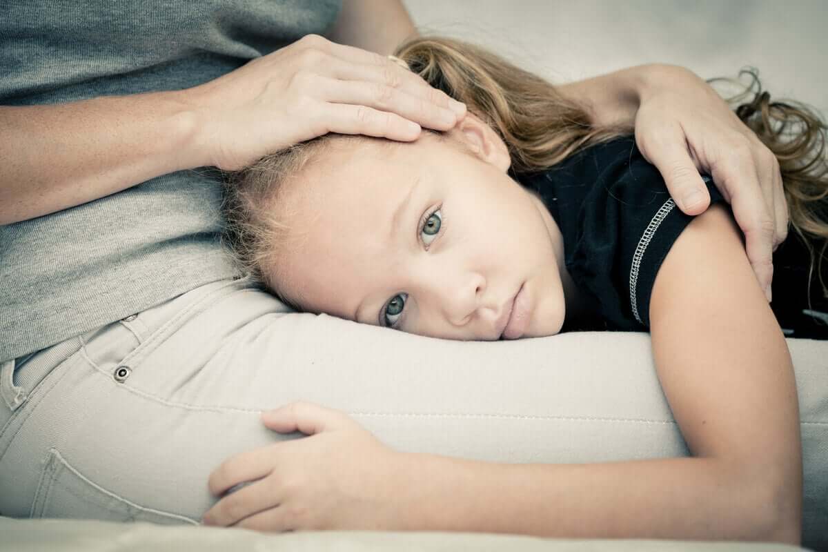 Criança com medo deitada no colo da mãe