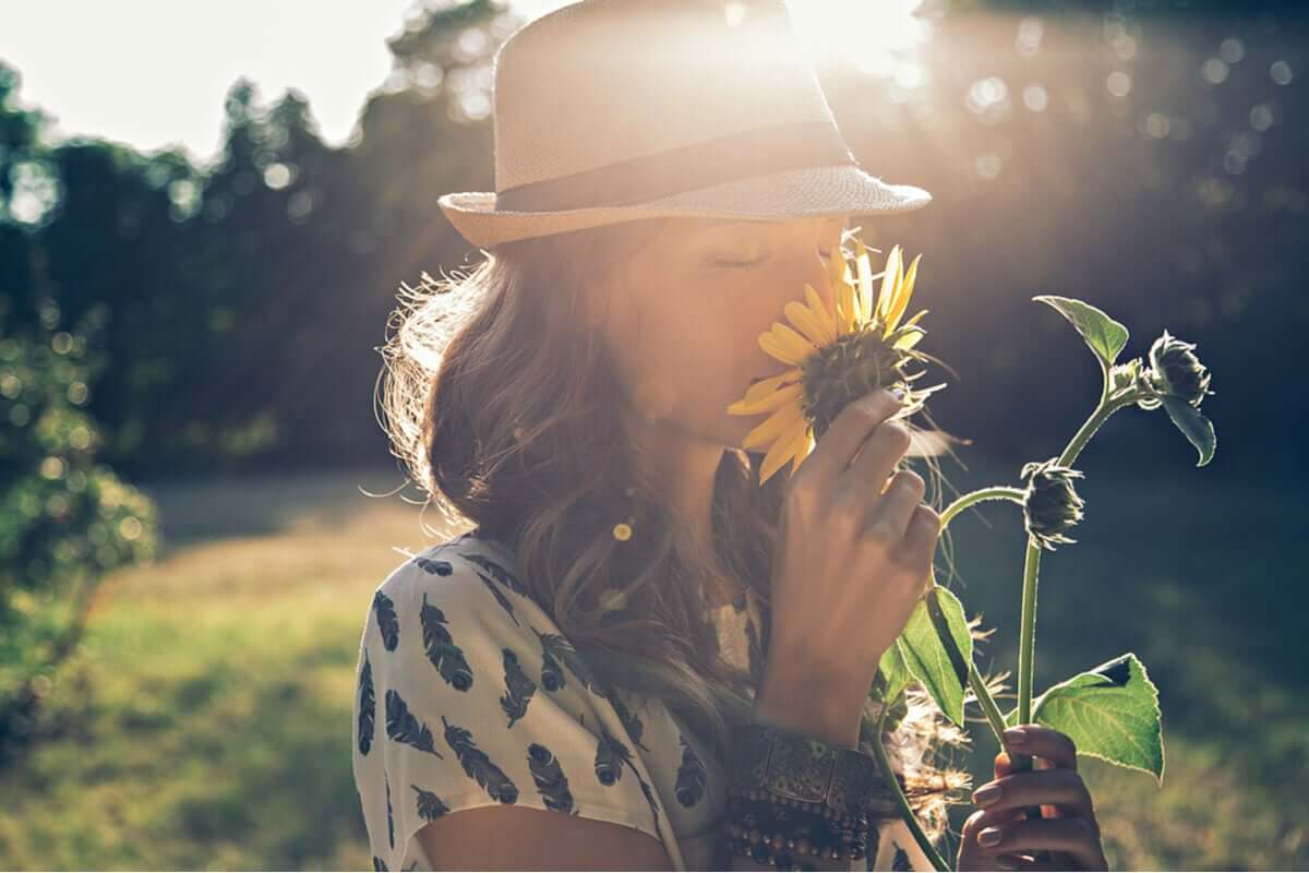 Mulher sentindo aroma de flor