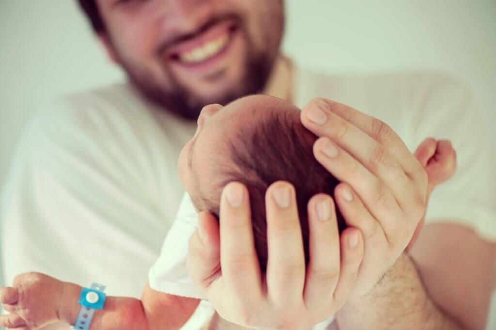 Pai segurando filho recém-nascido