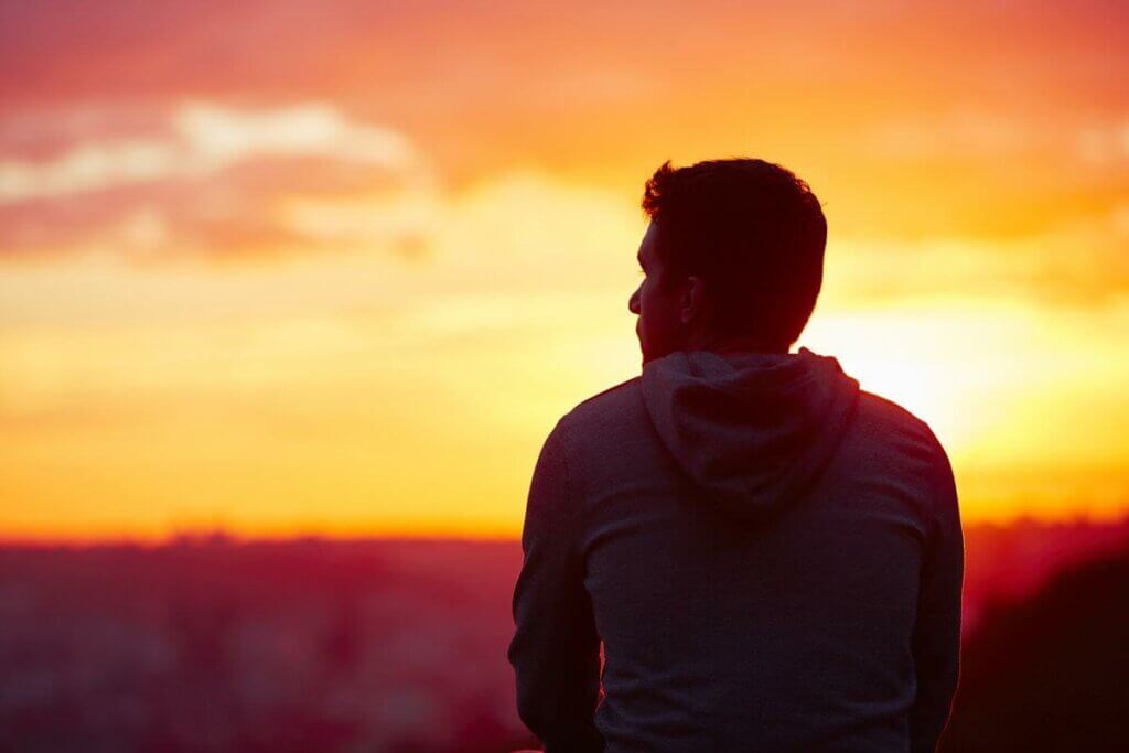 Homem observando o por do sol