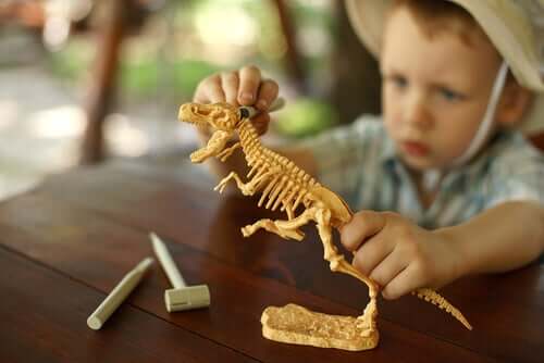 Menino brincando com dinossauro