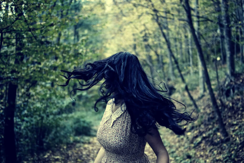 Mulher fugindo em floresta