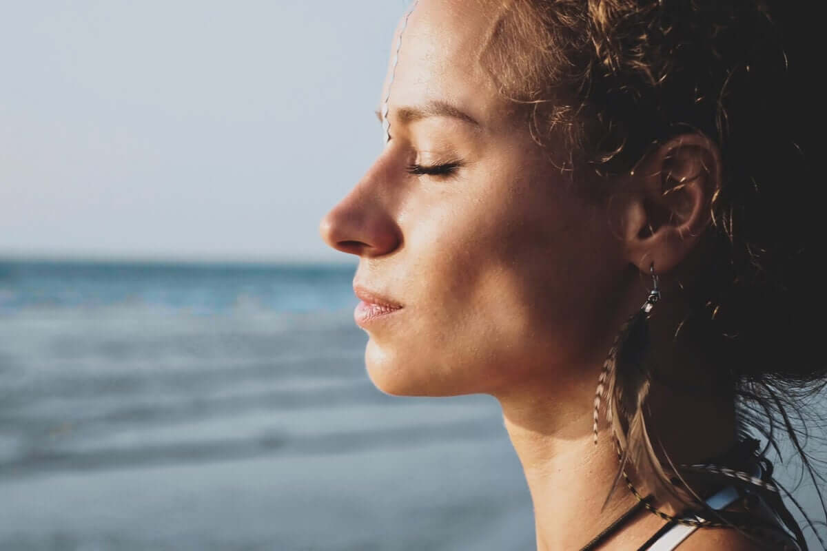Mulher de olhos fechados na praia