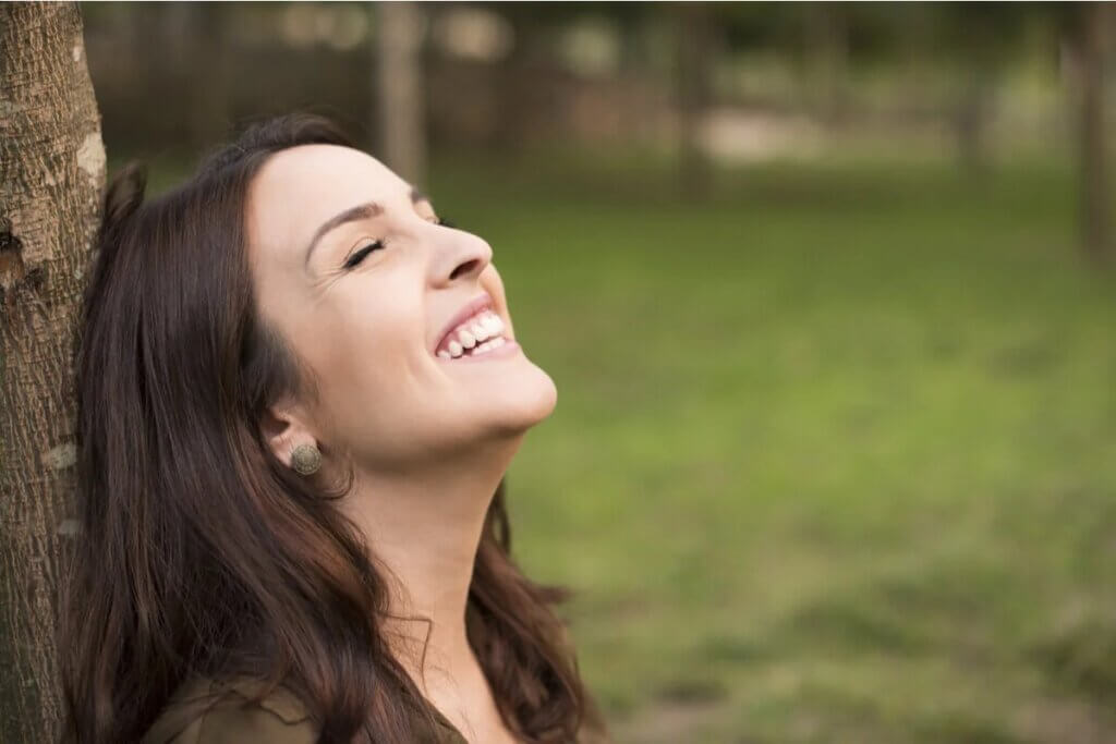 Mulher rindo ao ar livre