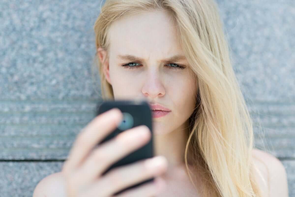 Mulher nervosa olhando celular