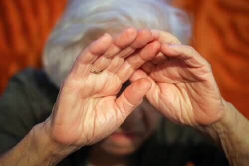 Idosa cobrindo o rosto