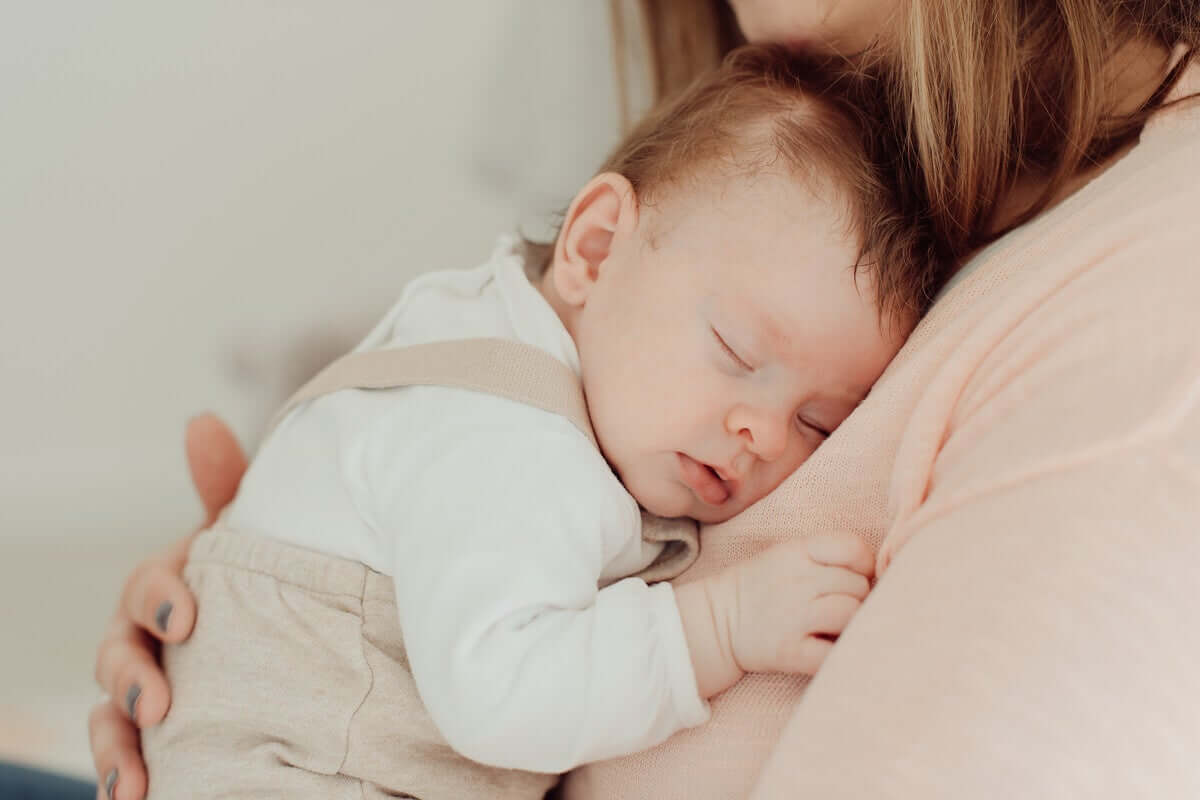 Bebê dormindo no colo da mãe