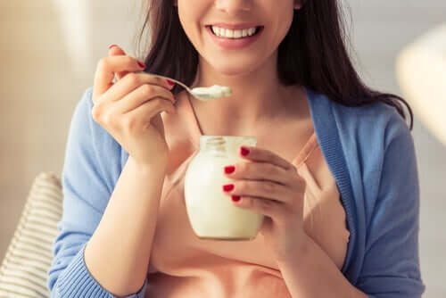 Mulher tomando iogurte natural
