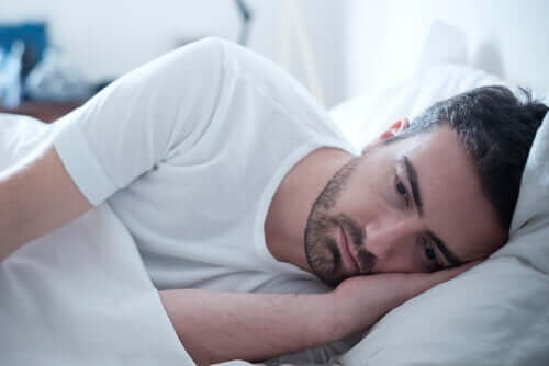 Homem triste deitado na cama