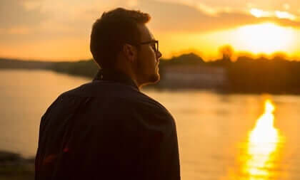 Jovem olhando o pôr do sol