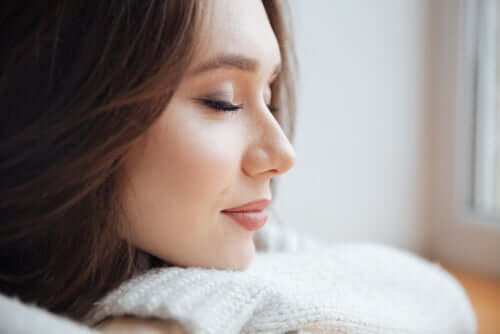 Mulher sorrindo de olhos fechados