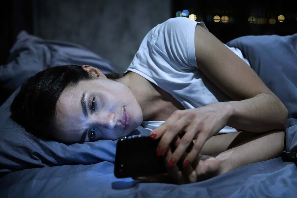 Mulher ao telefone antes de dormir